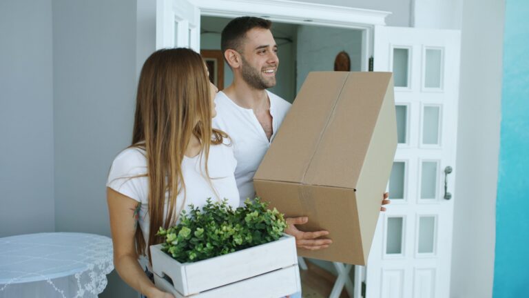 First-time home buyers standing together outside their new home