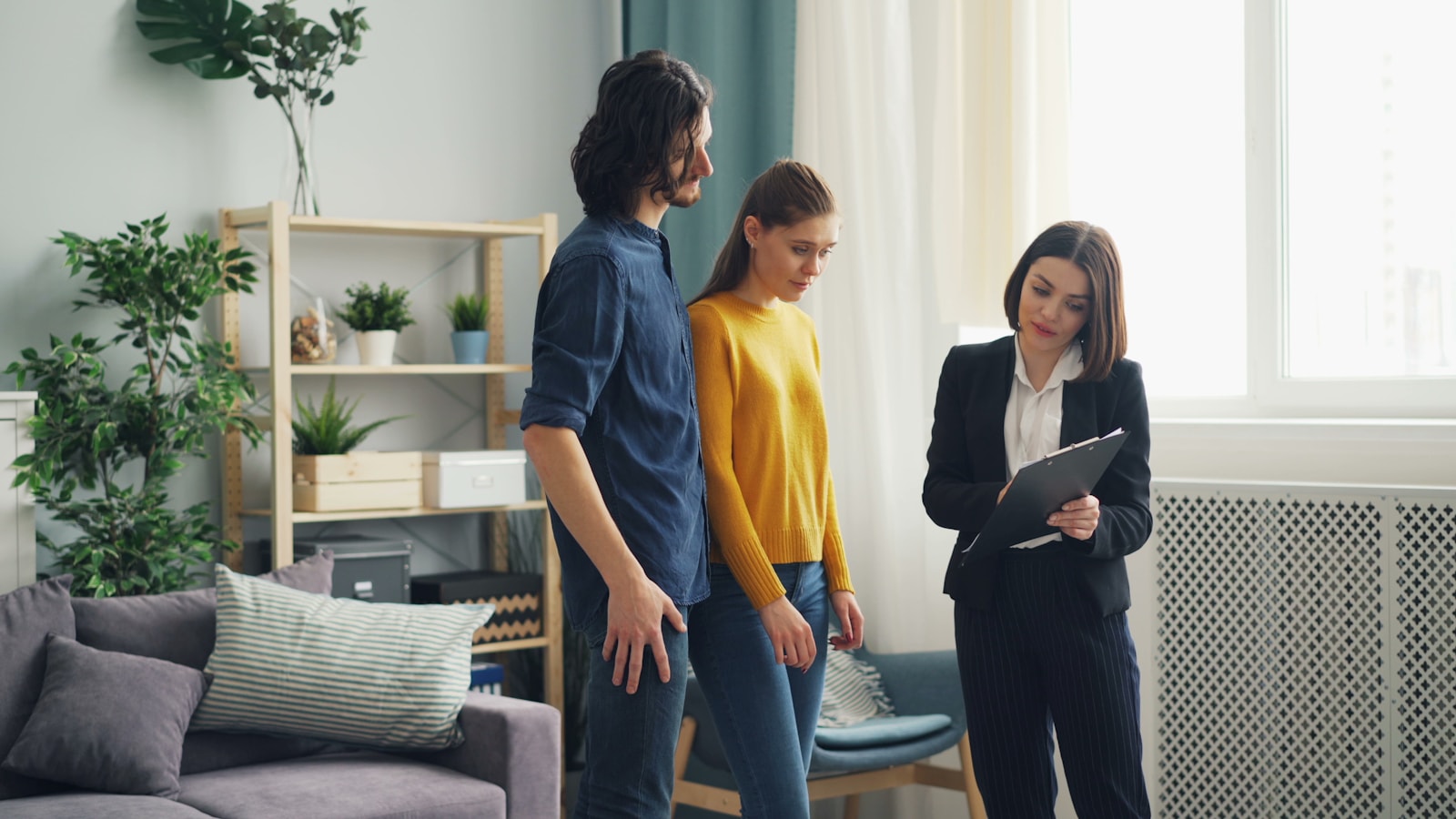 Prospective home buyers touring a house with a real estate professional