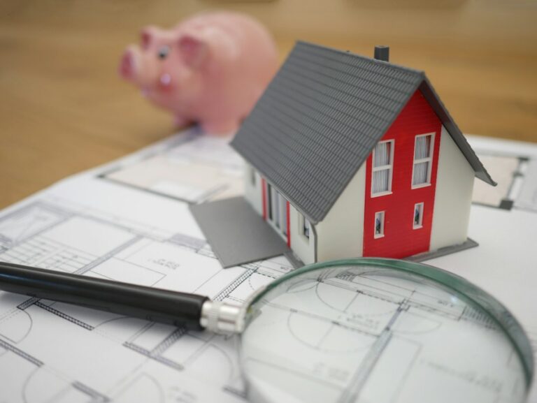 House model and paperwork illustrating a home sale during divorce